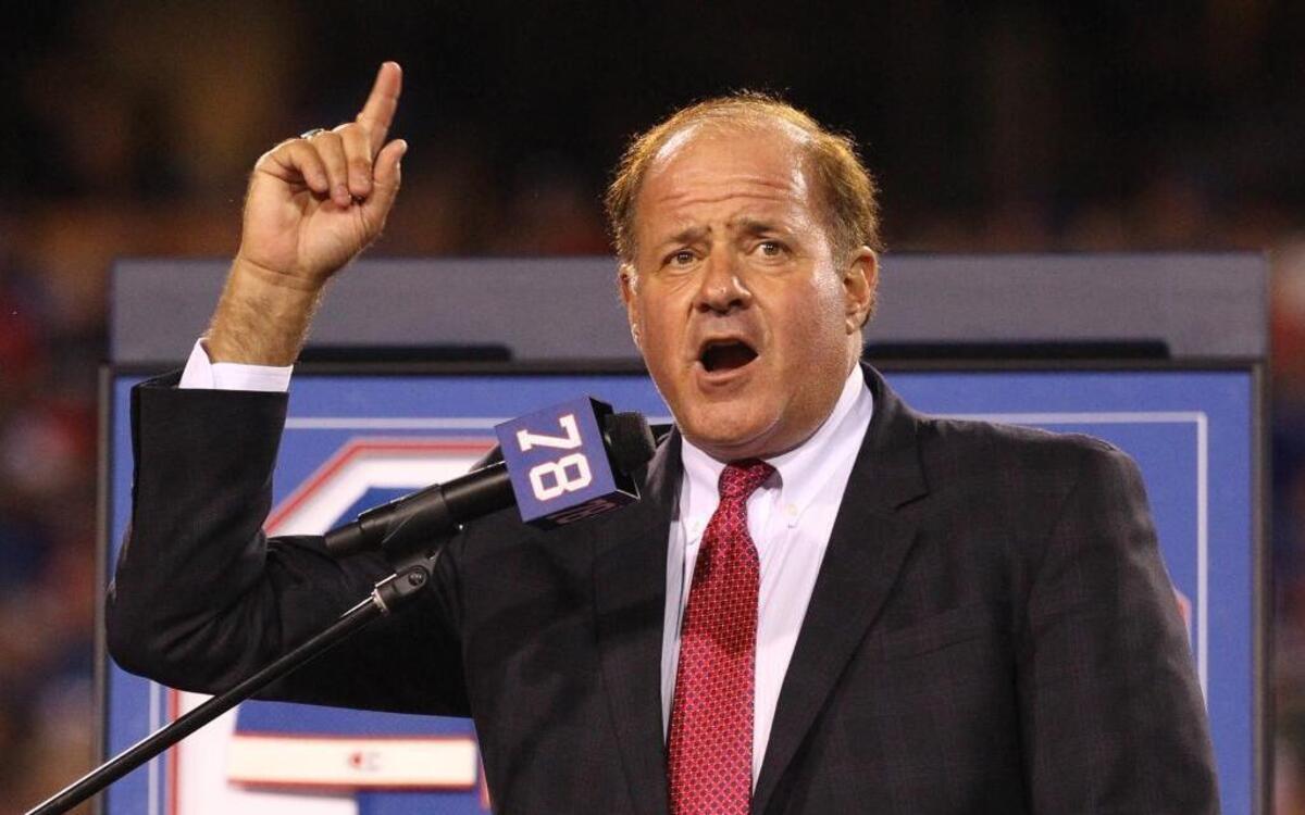 In this Sept. 15, 2016, file photo, Chris Berman introduces former Buffalo Bills Hall of Fame defensive end Bruce Smith during his jersey retirement ceremony at halftime of an NFL football game, in Orchard Park, N.Y. Berman isn't disappearing from in front of the cameras or from behind the microphones. He's simply stepping to the side a bit. The longtime ESPN fixture is giving up his regular on-air NFL and baseball spots for a new role at the network.
