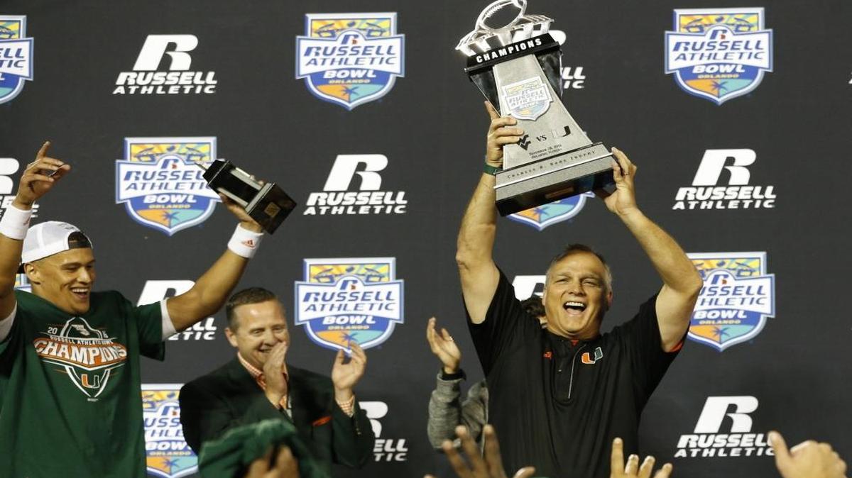 Miami Hurricanes head coach Mark Richt raises the Championship trophy after the University of Miami defeats West Virginia Mountaineers at the Russell Athletic Bowl in Orlando Wed., Dec. 28, 2016.