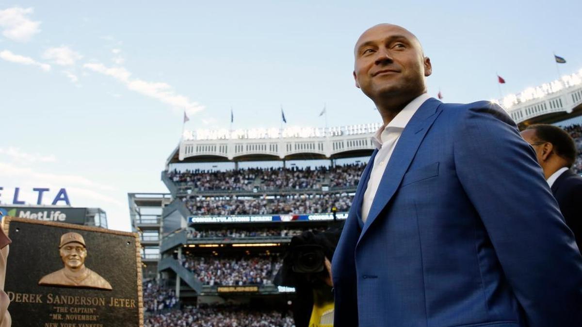 Retired New York Yankees shortstop Derek Jeter, right, looks around during a pregame ceremony after his No. 2 was retired in Monument Park at Yankee Stadium in New York, Sunday, May 14, 2017. The plaque is a replica of the one in Monument Park. (AP Photo/Pool, Kathy Willens)