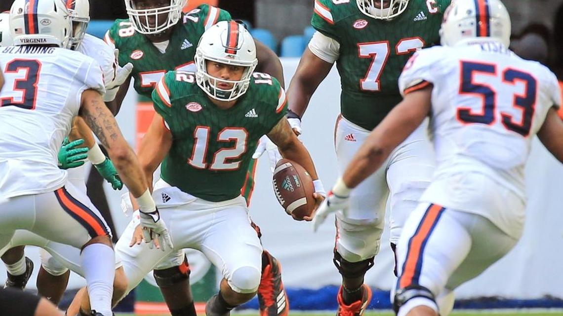 Miami Hurricanes quarterback Malik Rosier (12) scrambles in the first quarter as the University of Miami Hurricanes host the Virginia Cavaliers at Hard Rock Stadium on Sat., Nov. 18, 2017.