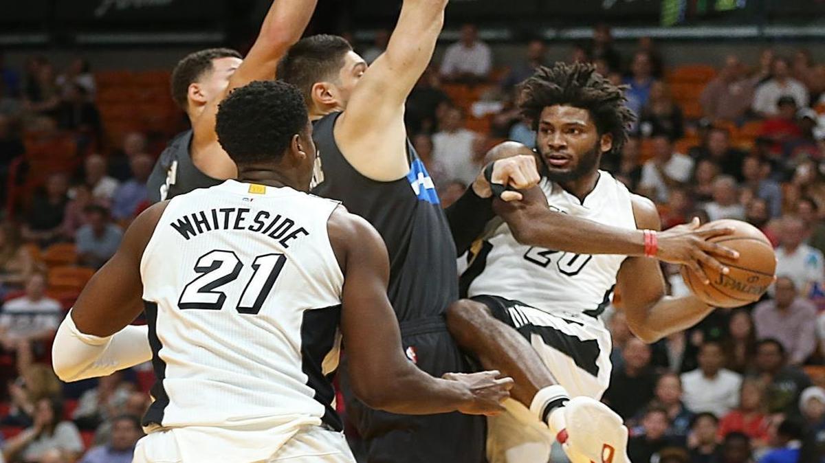 Miami Heat forward Justise Winslow, attempts to pass the ball to center Hassan Whiteside, against Magic's Nikola Vucevic, in the first quarter of the Miami Heat vs Orlando Magic, NBA game at AmericanAirlines Arena in Miami on Tues., Dec. 20, 2016.