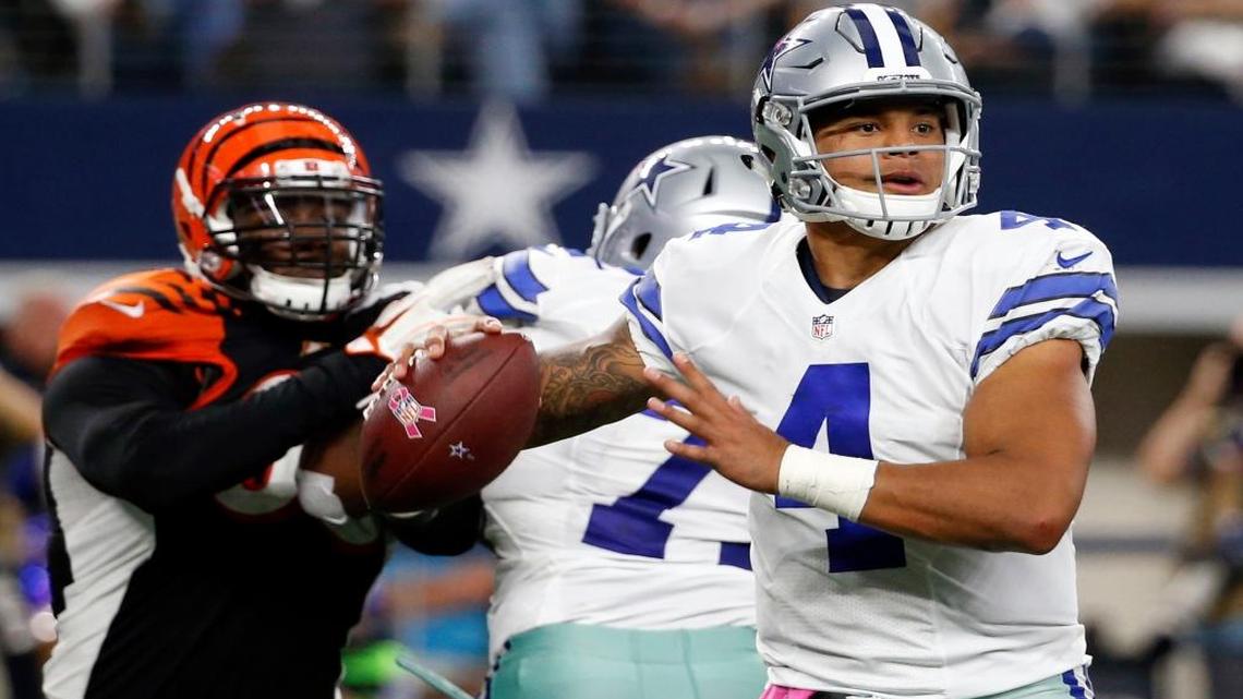 In this Sun, Oct. 9, 2016, file photo, Dallas Cowboys quarterback Dak Prescott (4) prepares to throw a pass under pressure from Cincinnati Bengals defensive end Michael Johnson, left, in the second half of an NFL football game in Arlington, Texas