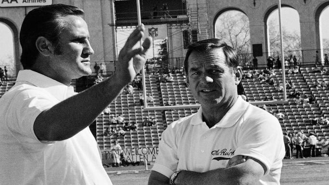Miami Dolphins head coach Don Shula, left, and Washington Redskins? defense coach Charley Winner inspect the turf of the Los Angeles Coliseum before the start of Super Bowl game on Jan. 14, 1973 in Los Angeles. The message appears on scoreboard.