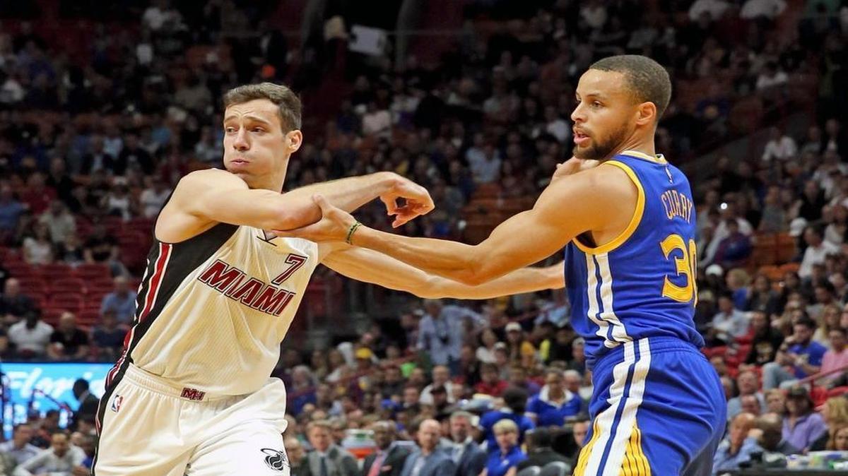 Miami Heat Goran Dragic and Golden State Warriors Stephen Curry wrestle in the key in the first quarter at the AmericanAirlines Arena, Miami, Florida, Jan. 23, 2017.