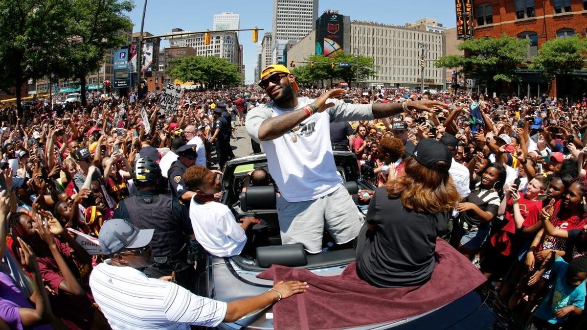 Cleveland Cavaliers' LeBron James, center, stands in the back of a Rolls Royce as it makes its way through the crowd lining the parade route in downtown Cleveland, Wed., June 22, 2016, celebrating the basketball team's NBA championship.