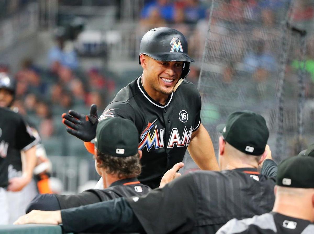 Miami Marlins' Giancarlo Stanton (27) is greeted at the dugout after hitting a two-run home run during the sixth inning of the team's baseball game against the Atlanta Braves on Friday, Aug. 4, 2017, in Atlanta. It was Stanton's second homer of the game.