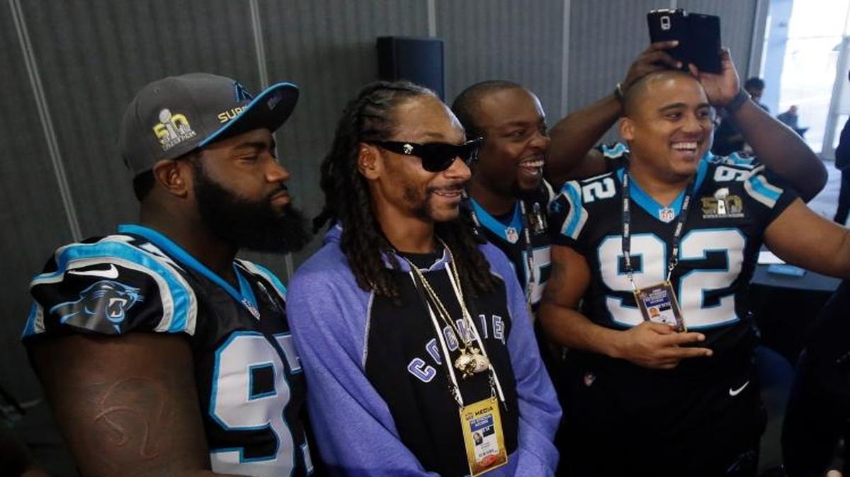 Carolina Panthers players takes selfies with recording artist Snoop Dogg, second from left, during a press conference in preparation for the Super Bowl 50 football game Thursday Feb. 4, 2016 in San Jose, Calif.