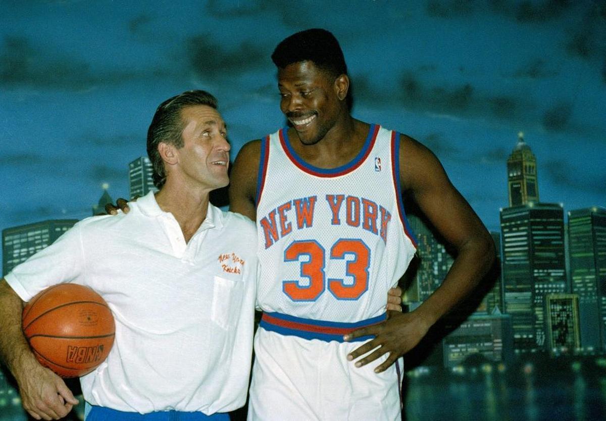In this Oct. 10, 1991, file photo, New York Knicks NBA basketball team head coach Pat Riley, left, and Knicks center Patrick Ewing, pose in front of a picture of the New York City skyline during the teams media day in Purchase, N.Y. Pat Riley often was forced to wonder if his time in the NBA was over. A half-century later, he's still in the game.