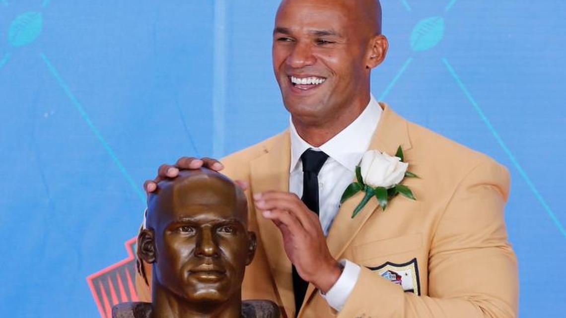 Former NFL player Jason Taylor poses with a bust of himself during an induction ceremony at the Pro Football Hall of Fame Saturday, Aug. 5, 2017, in Canton, Ohio.