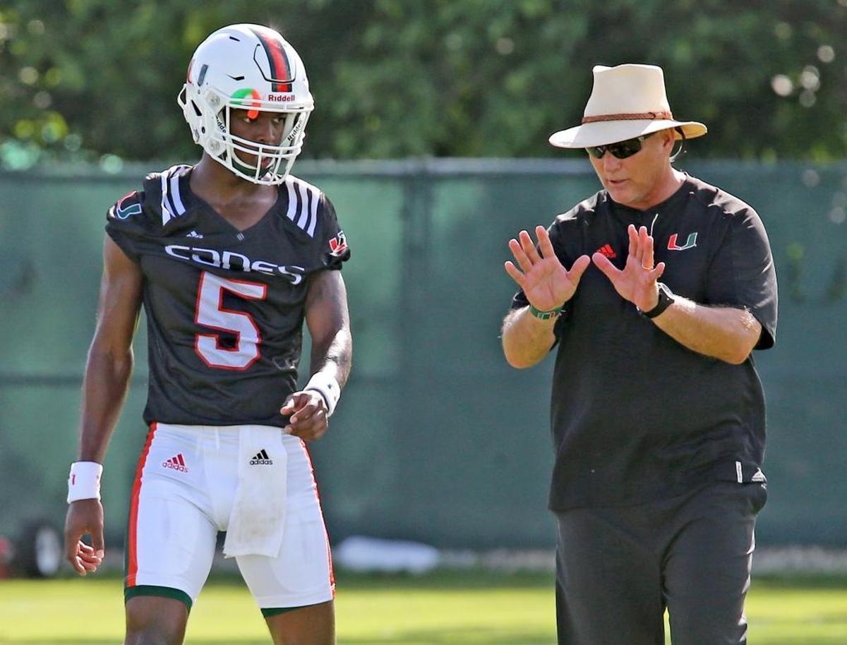 UM's head coach Mark Richt works with quarterback N'Kosi Perry at the University of Miami's first day of football practice for the 2017 season on Aug. 1, 2017.