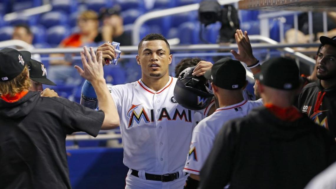 Miami Marlins right fielder Giancarlo Stanton is congratulate by teammates after scoring a during the first inning of a baseball game against the San Francisco Giants at Marlins Park on Wednesday, Aug. 16, 2017 in Miami.
