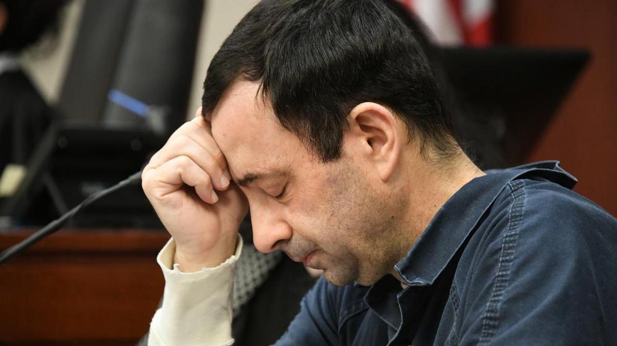 A victim makes her “impact statement” to Larry Nassar during a sentencing hearing as he puts his head down in front of Judge Rosemarie Aquilina in district court in Lansing, Michigan. Nassar has pleaded guilty to molesting females with his hands at his Michigan State University office, his home and a Lansing-area gymnastics club, often while their parents were in the room.