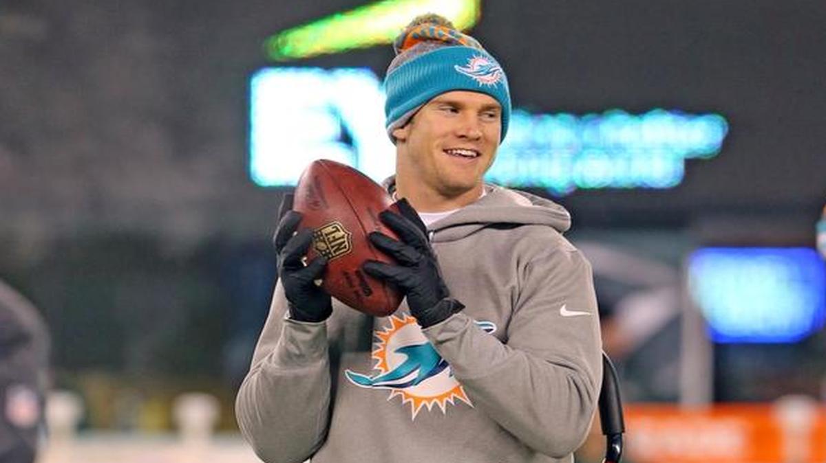 Miami Dolphins Ryan Tannehill stands on a crutch during warmups as Matt Moore prepares to lead the Fins against the New York Jets at MetLife Stadium in East Rutherford, New Jersey, Dec. 17, 2016.