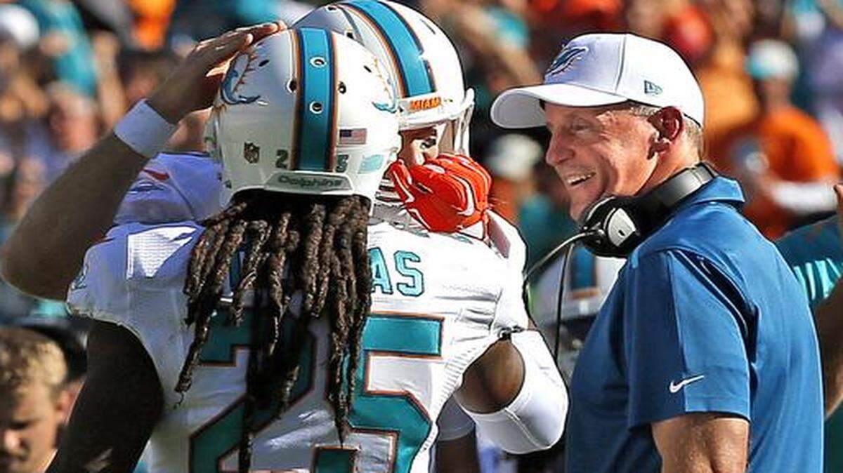 
Miami Dolphins coach Joe Philbin smiles after officials overturn a ruling on the field and ruled Jarvis Landry a touchdown at Sun Life Stadium in Miami Gardens, Florida, on Sunday, Nov. 2, 2014. Louis Delmas grabs Tannehill's face mask in celebration.
