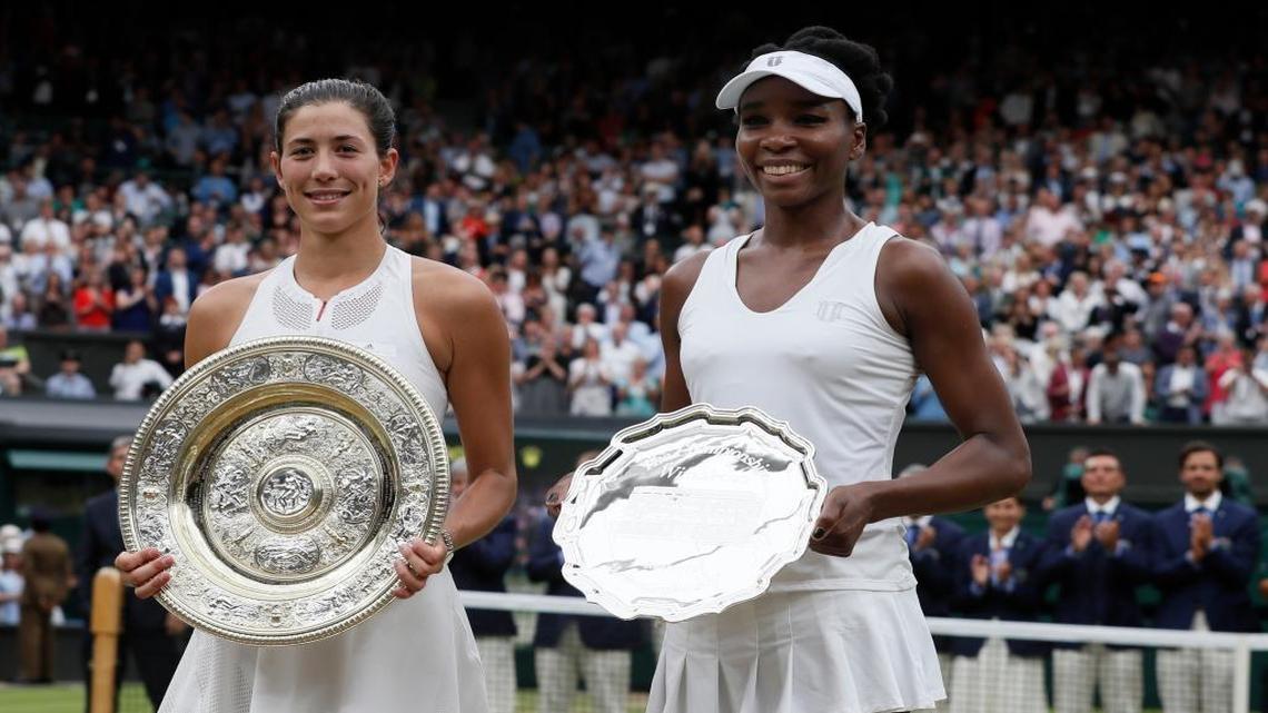 Spain's Garbine Muguruza, left, holds the winners trophy after defeating Venus Williams of the United States, right, in the Women's Singles final match on day twelve at the Wimbledon Tennis Championships in London Saturday, July 15, 2017.