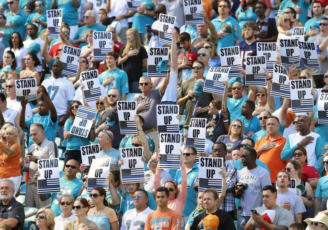 Dolphin fans hold stand up signs as a counter 49ers quarterback Colin Kaepernick (7) who took a knee during the national anthem as the Miami Dolphins host the 49ers at Hard Rock Stadium in Miami Gardens on Sun., Nov. 27, 2016