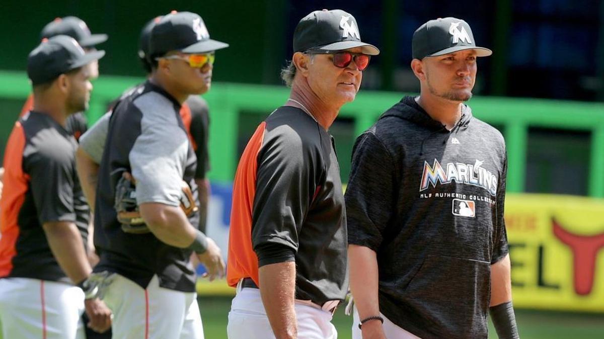 Miami Marlins Manager Don Mattingly chats with infielder Miguel Rojas on Wednesday at Marlins Park before Thursday’s Opening Day vs. the Cubs.