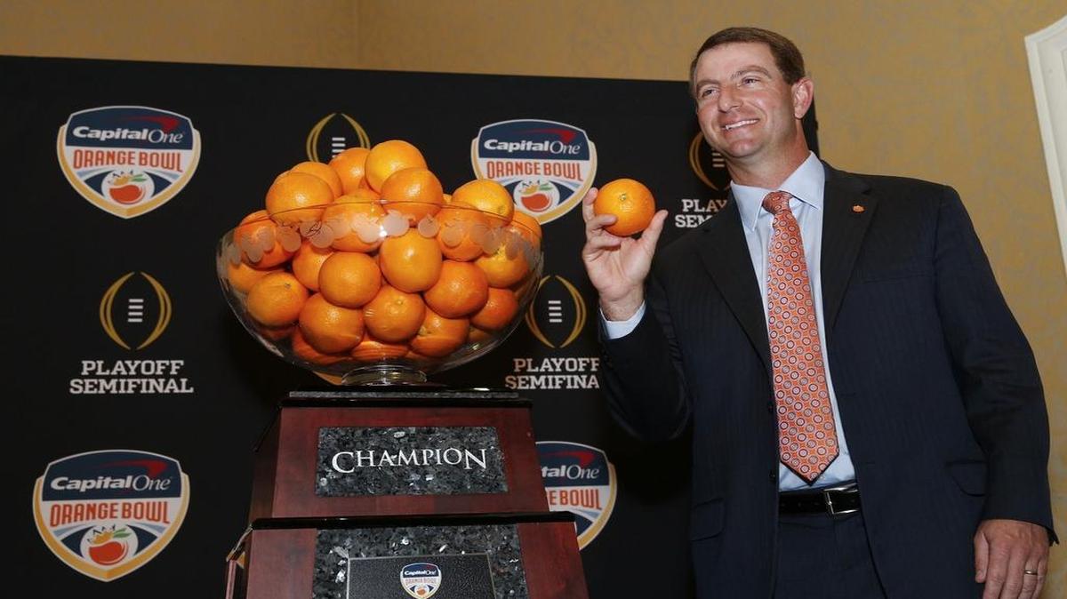 Coach Dabo Sweeney of No. 1 Clemson stands next to the Orange Bowl Trophy that is topped with a bowl of oranges during a news conference at the Renaissance Hotel in Fort Lauderdale.