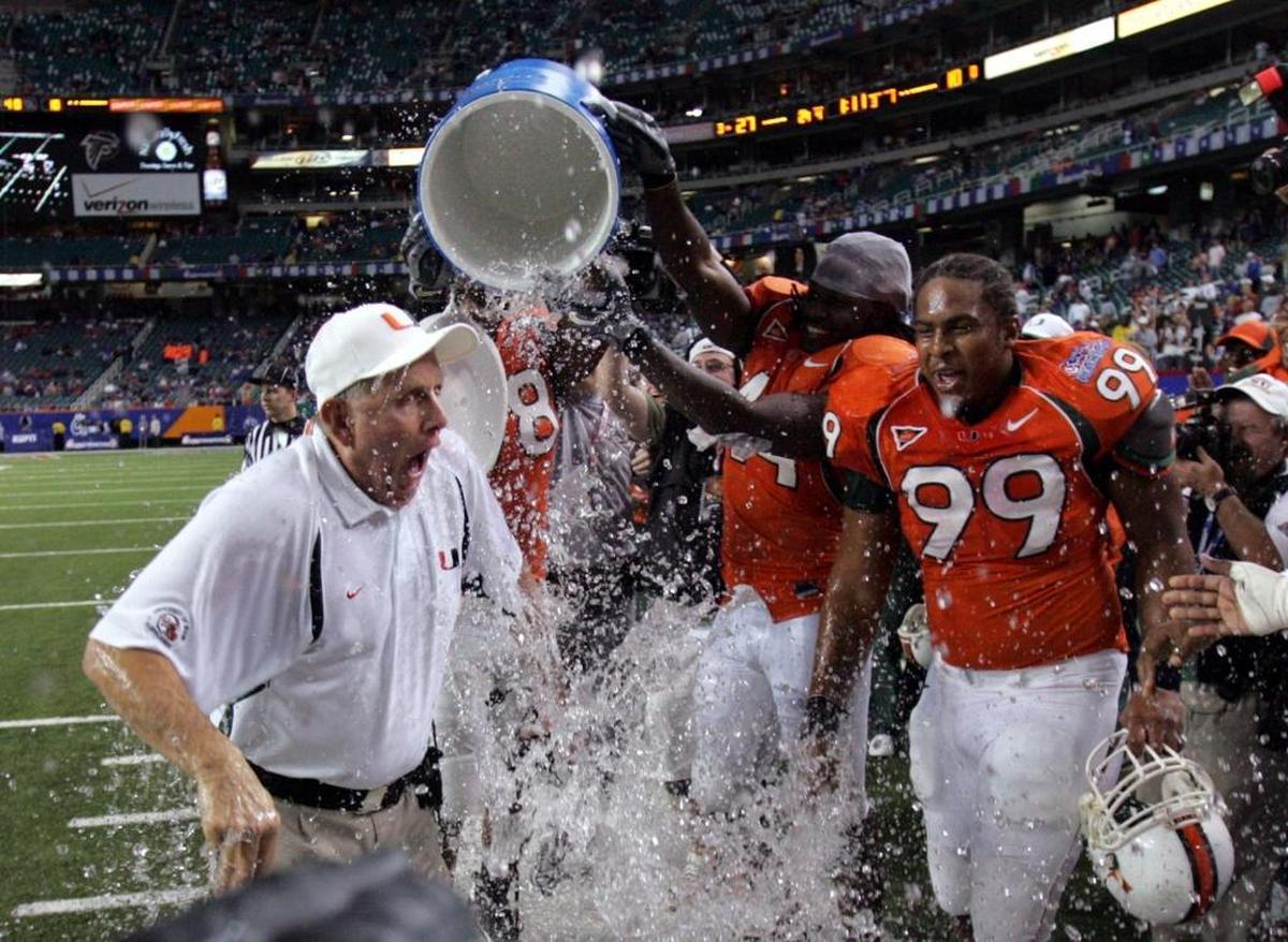 Miami coach Larry Coker is doused by Leon Williams, center, and another player, left, as Kareem Brown (99) watches at the close of Miami's 27-10 win over Florida in the Peach Bowl on Fri., Dec. 31, 2004, in Atlanta.