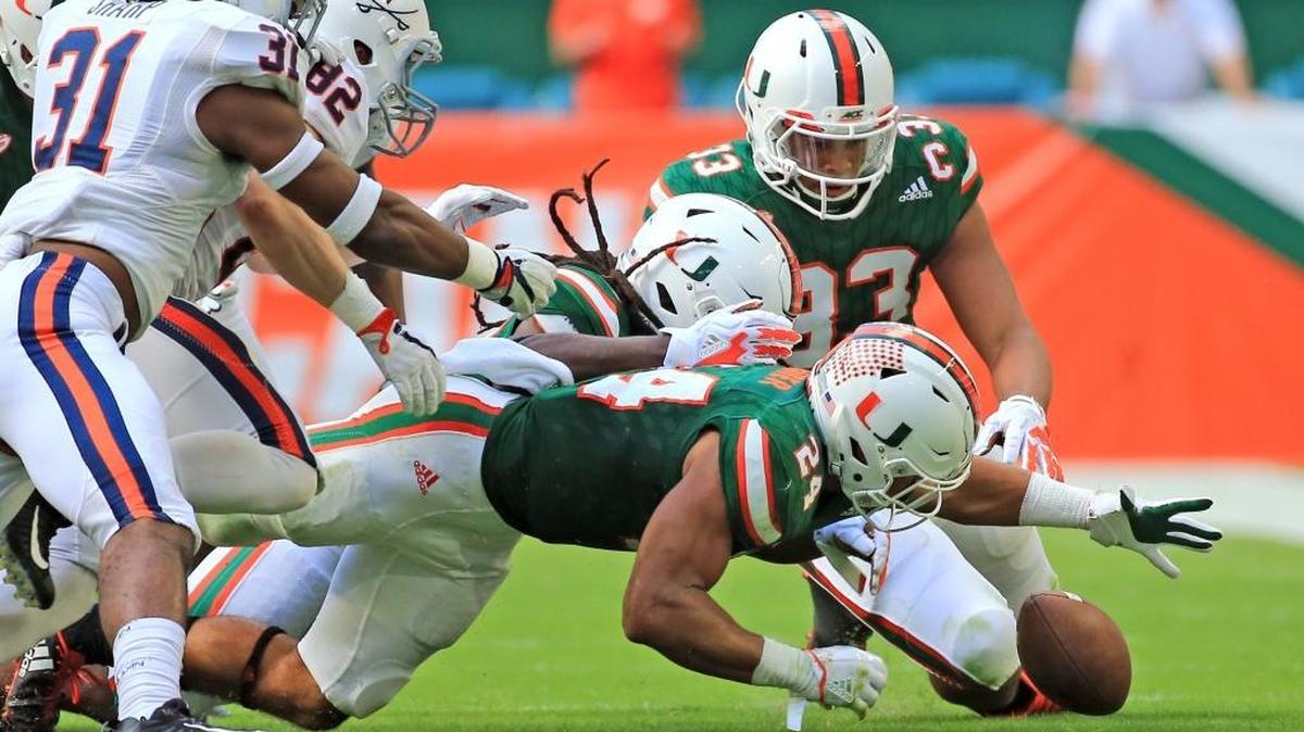 Virginia Cavaliers running back Daniel Hamm (22) fumbles a punt return as Miami Hurricanes running back Travis Homer (24) picks it up in the second quarter as the University of Miami Hurricanes host the Virginia Cavaliers at Hard Rock Stadium on Saturday, November 18, 2017.