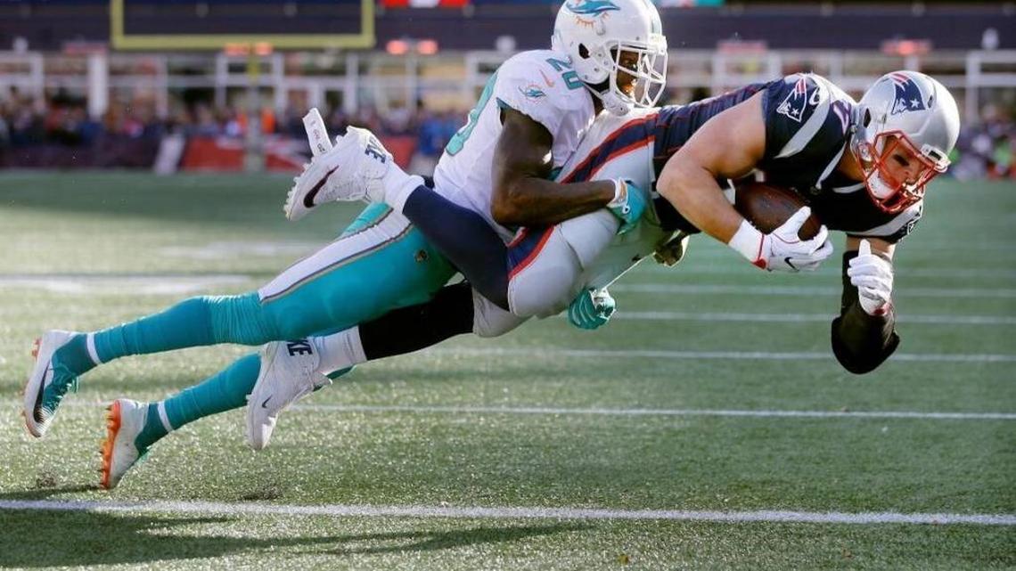 The Pats’ Rob Gronkowski carries Dolphins safety Reshad Jones into the end zone in a 35-17 New England win over Miami last November in Foxborough, Mass.