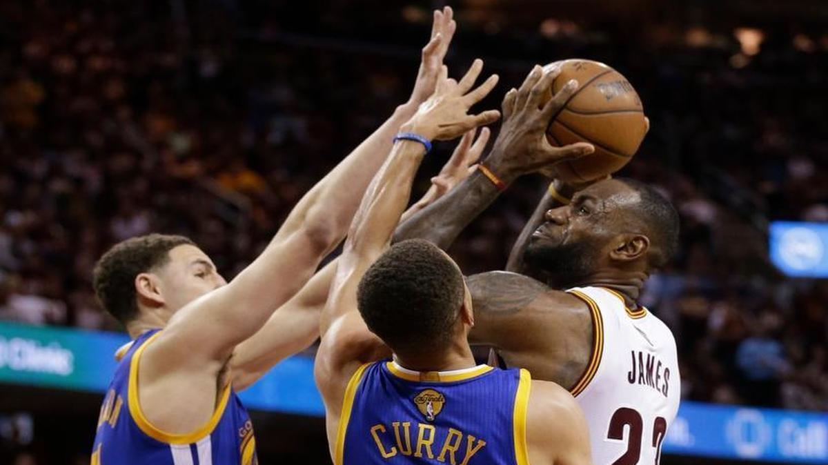 Cleveland Cavaliers forward LeBron James, right, is defended by Golden State Warriors guard Klay Thompson, left, and Golden State Warriors guard Stephen Curry during the second half of Game 3 of basketball's NBA Finals in Cleveland, Wed., June 8, 2016.