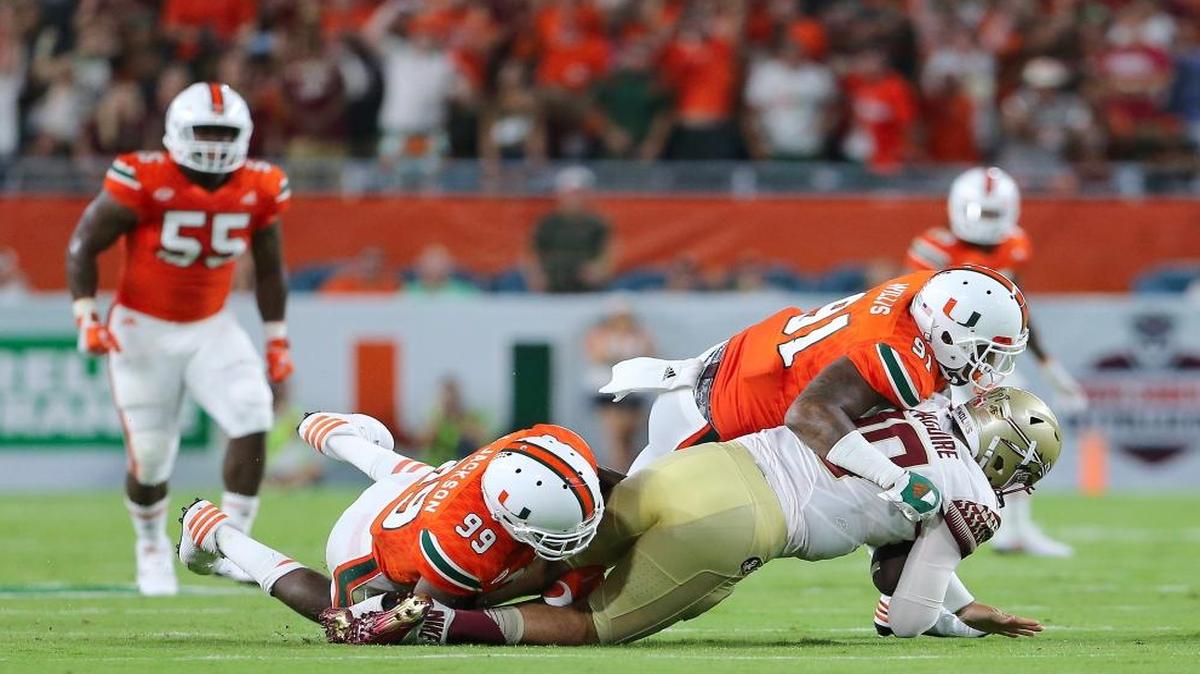 University of Miami Hurricanes linebacker Gerald Willis (91) and teammate defensive linemen Joe Jackson (99) sacks Florida State Seminoles quarterbacks Sean Maguire in the second quarter at Hard Rock Stadium on Saturday, Oct. 8, 2016, in Miami Gardens.