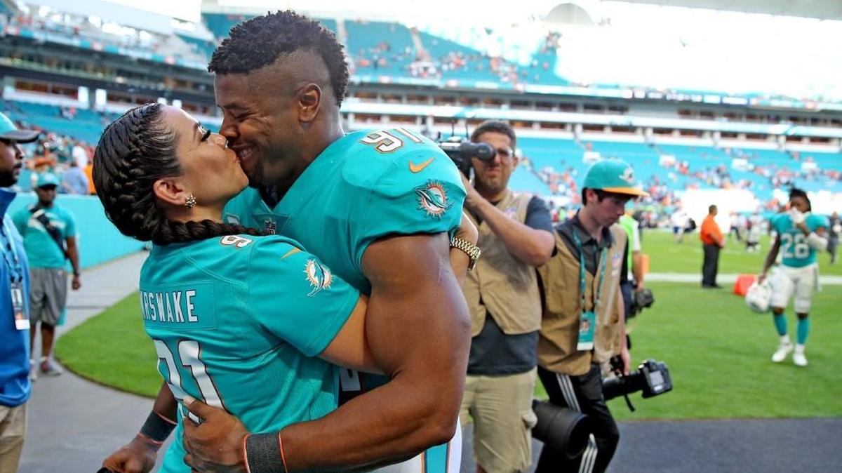 Miami Dolphins defensive end Cameron Wake kisses his wife after he comes off the field after defeating the Denver Broncos at Hard Rock Stadium in Miami Gardens, Florida, Dec. 3, 2017.
