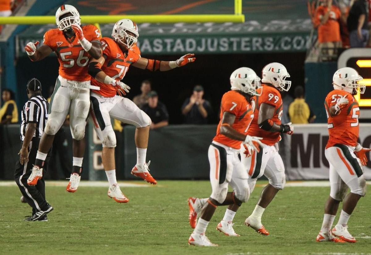 Marcus Robinson and Anthony Chickillo of the University of Miami, celebrate the final stop inthe win over Ohio State at Sun Life Stadium in Miami Gardens Florida, Sept. 17, 2011.