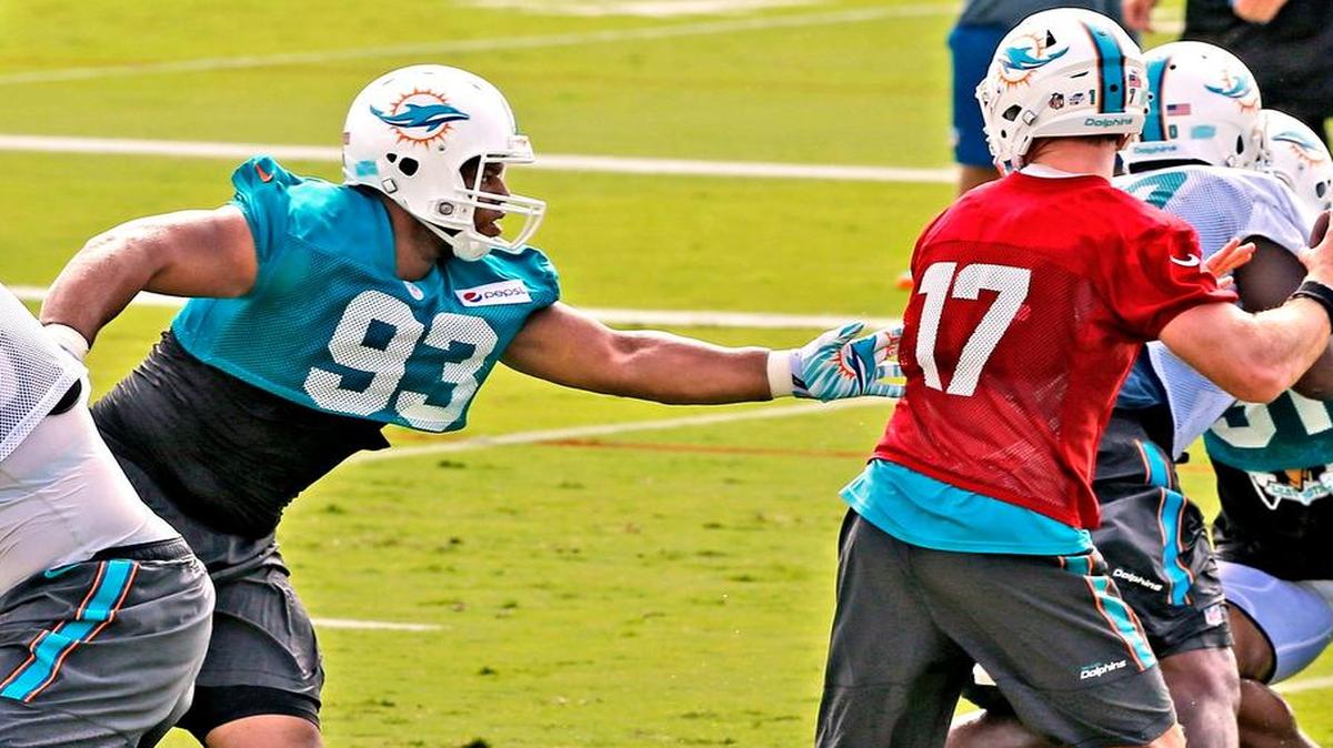 
Defensive tackle Ndamukong Suh reaches for quarterback Ryan Tannehill during the first day of training camp Thursday, July 30, 2015 in Davie.
