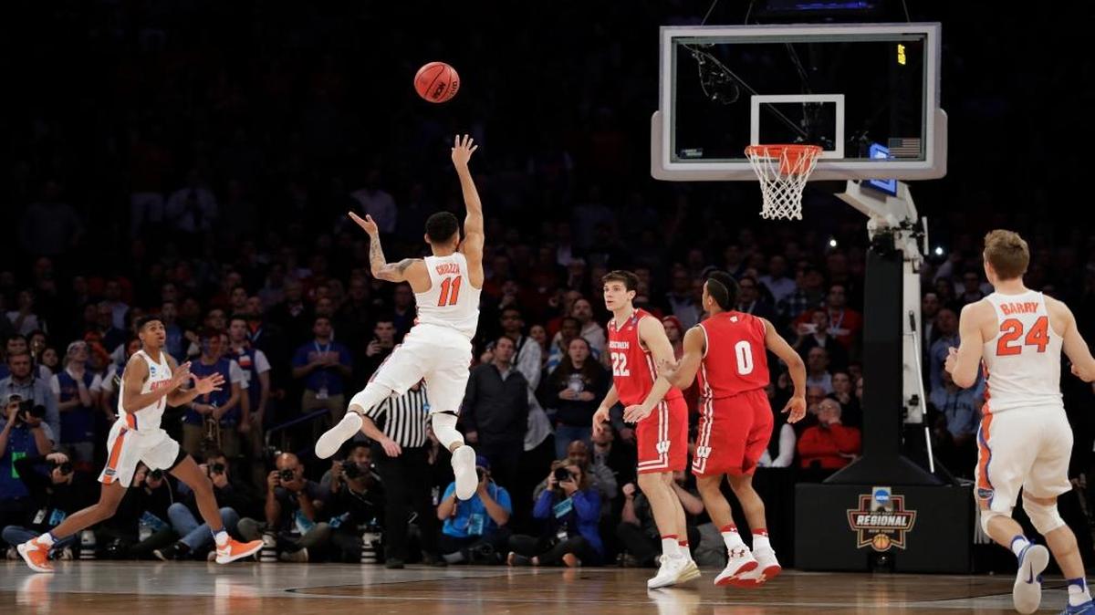 Florida guard Chris Chiozza (11) puts up a last second 3-point shot to score the game-winning points against Wisconsin in overtime of an East Regional semifinal game of the NCAA men's college basketball tournament, Saturday, March 25, 2017, in New York. Florida won 84-83.