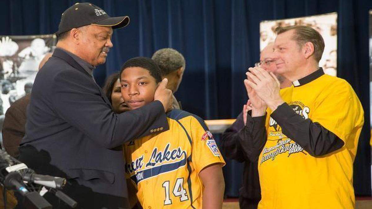 
Brandon Green, a catcher and pitcher for the Jackie Robinson West Little League baseball team, is embraced by civil rights leader Rev. Jesse Jackson following a press conference that was called after the team learned it would be stripped of their national champion title February 11, 2015 in Chicago.

