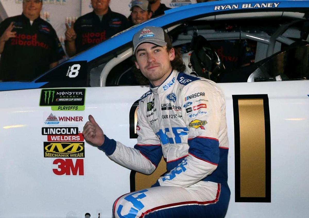 Ryan Blaney points to the pole award stuck on his car after winning the starting position for a NASCAR Cup Series auto race at Phoenix International Raceway, Friday, Nov. 10, 2017, in Avondale, Ariz.