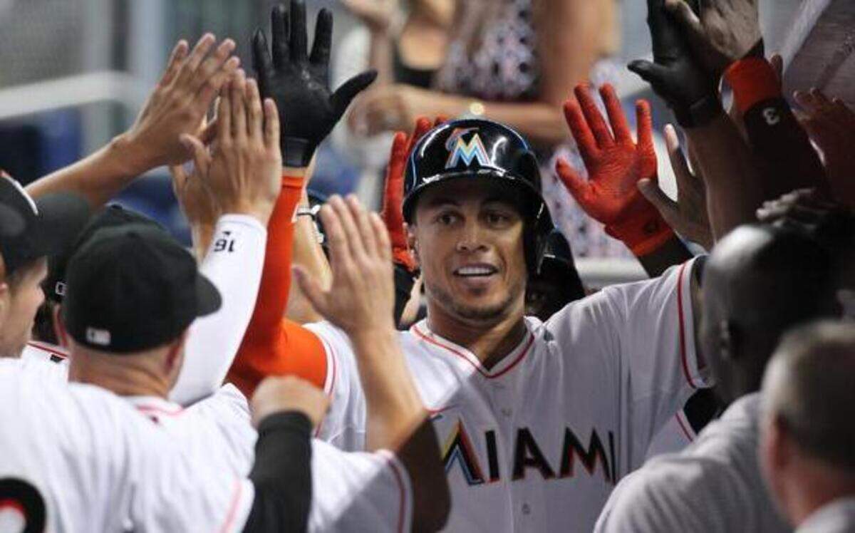 
Miami Marlins right fielder Giancarlo Stanton is congratulated by his teammates after hit three-run home run in the first inning of a Major League Baseball game against the Washington Nationals on Tuesday, April 15, 2014, at Marlins Park in Miami.
