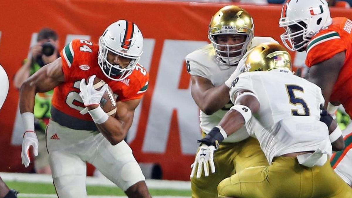 Miami Hurricanes Travis Homer (24) fights his way through the Notre Dame defensive line in the first quarter Saturday, Nov. 11, 2017, at Hard Rock Stadium in Miami Gardens, Fla.