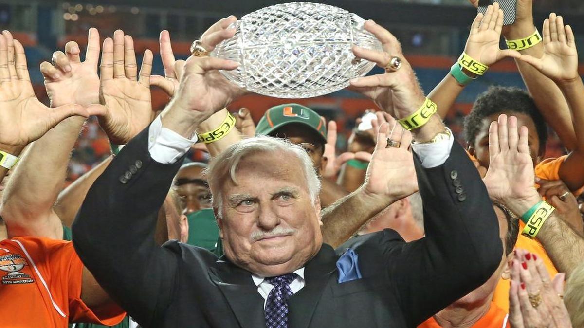 
Howard Schnellenberger raises the 1983 NCAA national championship trophy during a halftime ceremony at the University of Miami game vs. FAU on Friday, Aug. 30, 2013.
