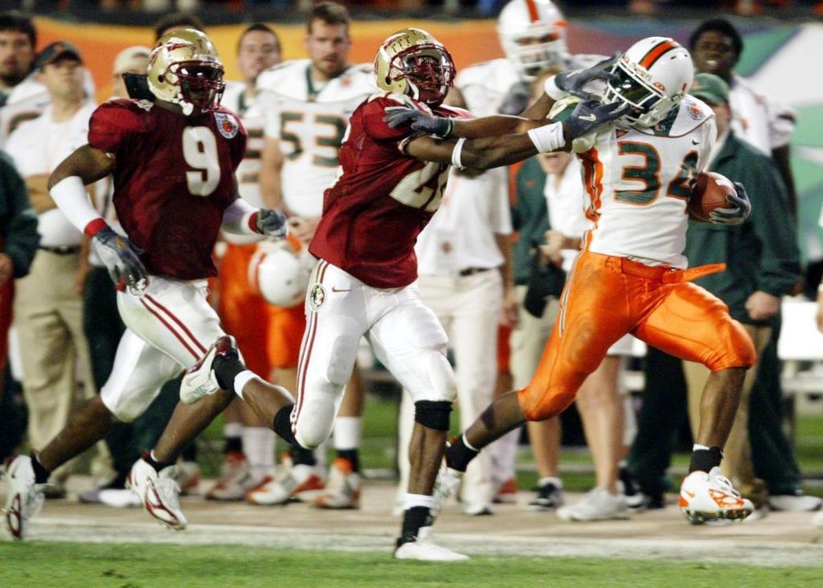 Miami's Jarrett Payton races down the sideline being chased by Florida State's Marlon Napier as the Miami Hurricanes faced the Florida State Seminoles in the Orange Bowl, Thurs., Jan. 1, 2004 in Miami, Florida.