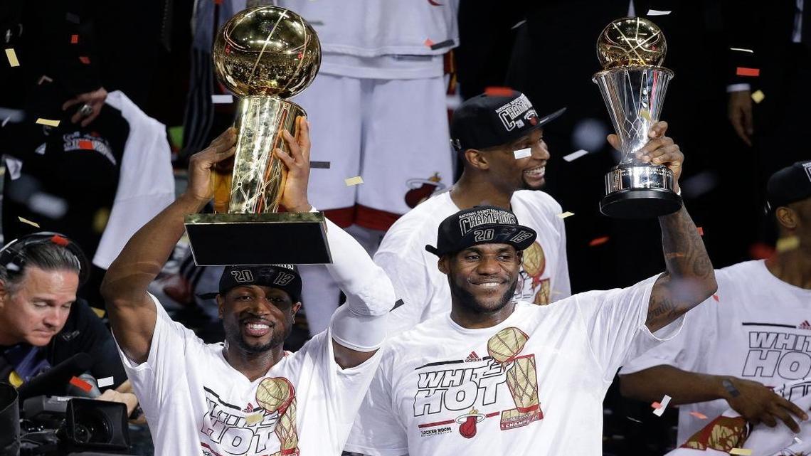 FILE - In this June 21, 2013, file photo, Miami Heat's Dwyane Wade, left, holds the Larry O'Brien NBA Championship Trophy as teammate LeBron James holds his Bill Russell NBA Finals Most Valuable Player Award after Game 7 of the NBA basketball championship against the San Antonio Spurs in Miami.