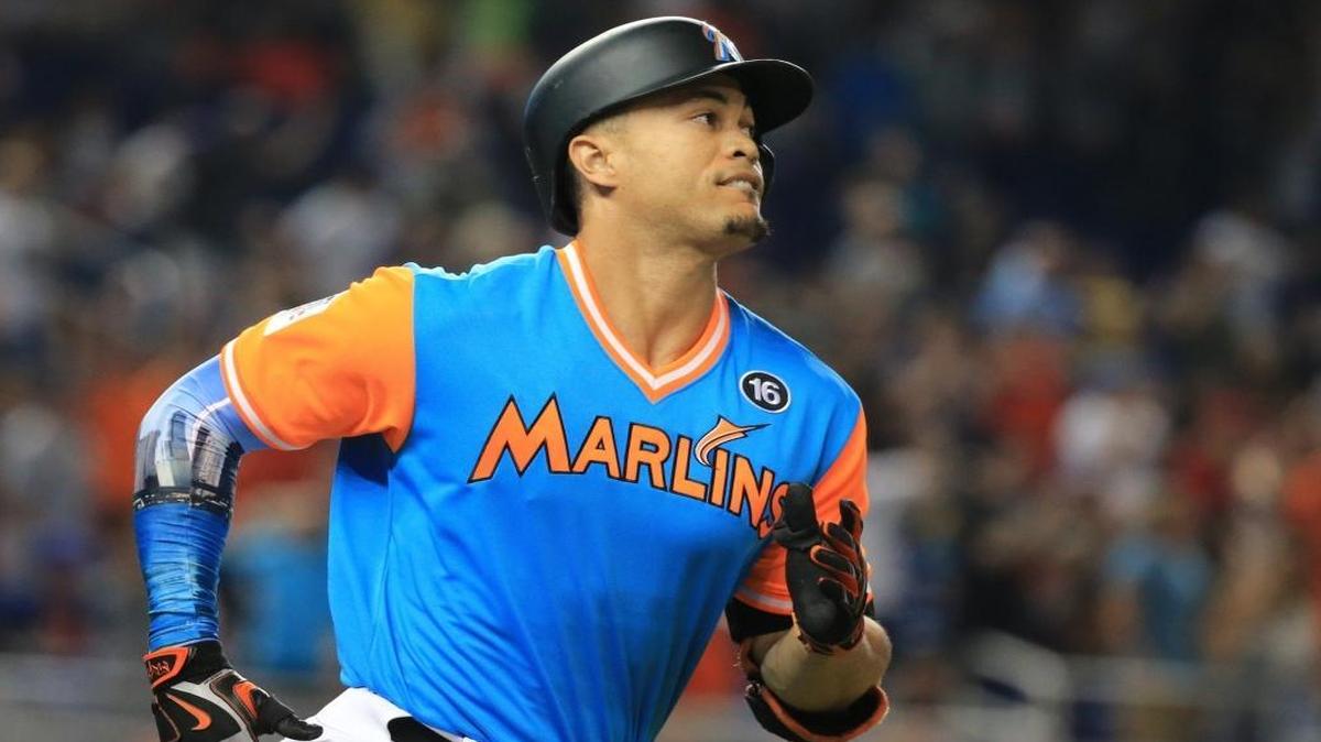 Miami Marlins right fielder Giancarlo Stanton (27) hits a home run and brings in second baseman Dee Gordon (9) to score in the first inning as the Marlins host the San Diego Padres at Marlins Park on Friday, Aug. 25, 2017.