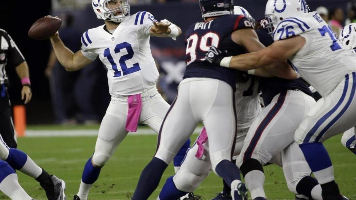 
Indianapolis Colts' Andrew Luck (12) throws as Houston Texans' J.J. Watt (99) applies pressure during the first quarter Thursday, Oct. 9, 2014, in Houston. 
