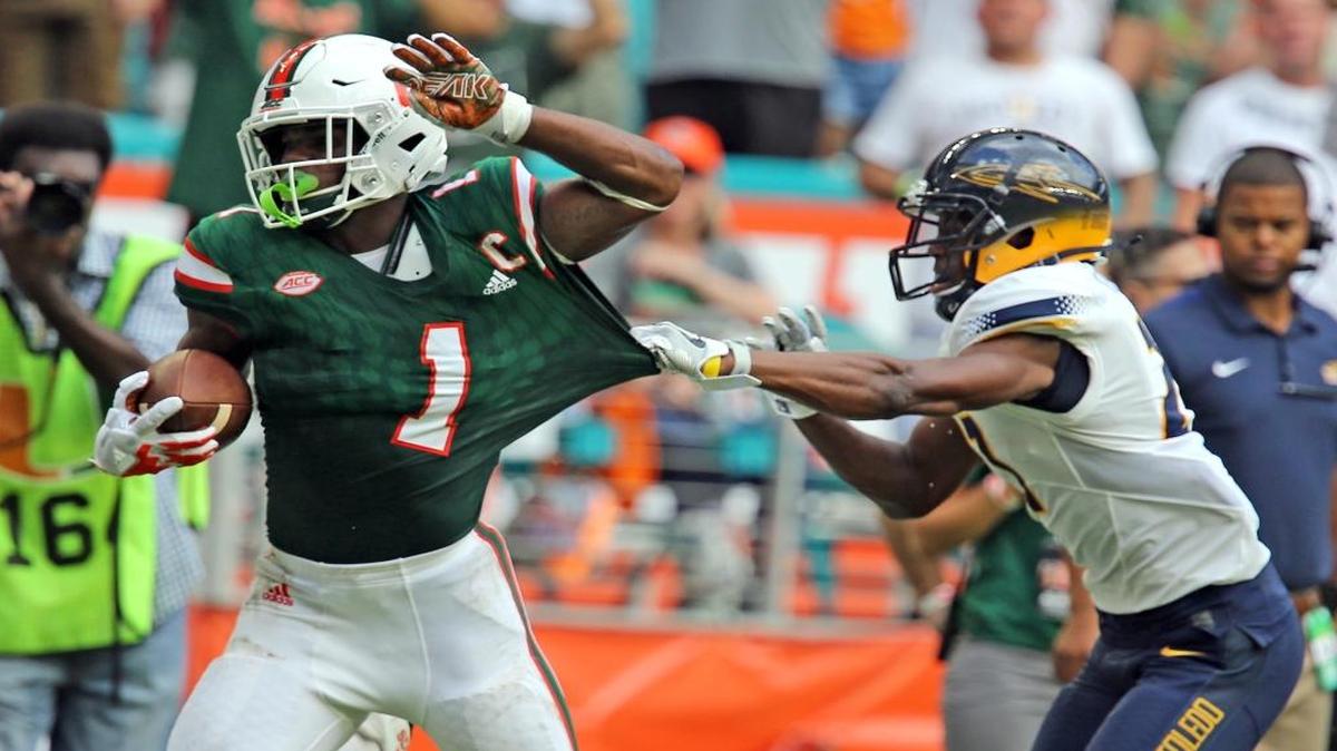 Miami Hurricanes Mark Walton (1) runs for a large gain as Toledo Rockets Kahill Robinson (27) stops him short of the goal in the first quarter Saturday, Sept. 23, 2017, at Hard Rock Stadium in Miami Gardens.
