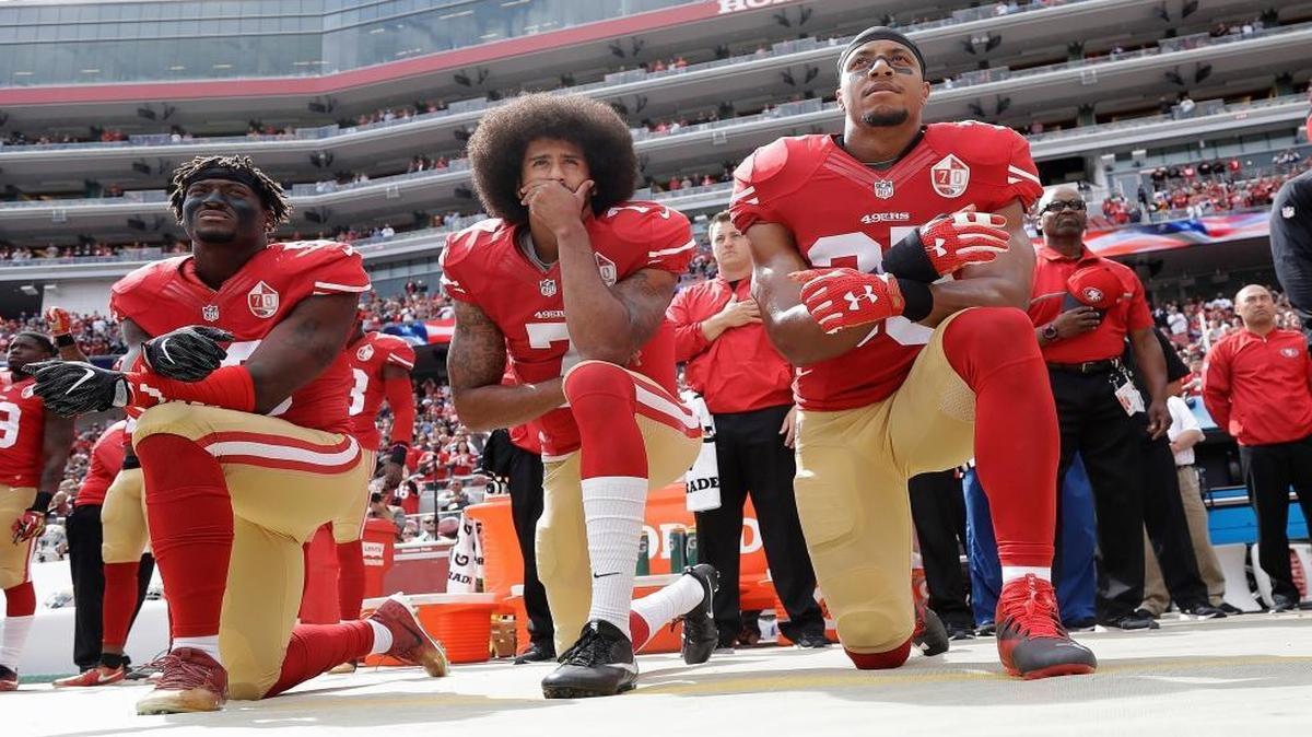 From left, 49ers linebacker Eli Harold, quarterback Colin Kaepernick and safety Eric Reid kneel in protest during the national anthem on Oct. 2, 2016.