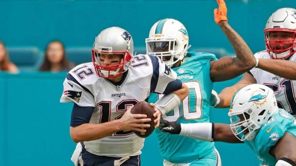 The Patriots’ Tom Brady, being chased here by Dolphins, also is being chased by New Orleans’ Drew Brees in the Miami Herald’s tightening NFL quarterback rankings.