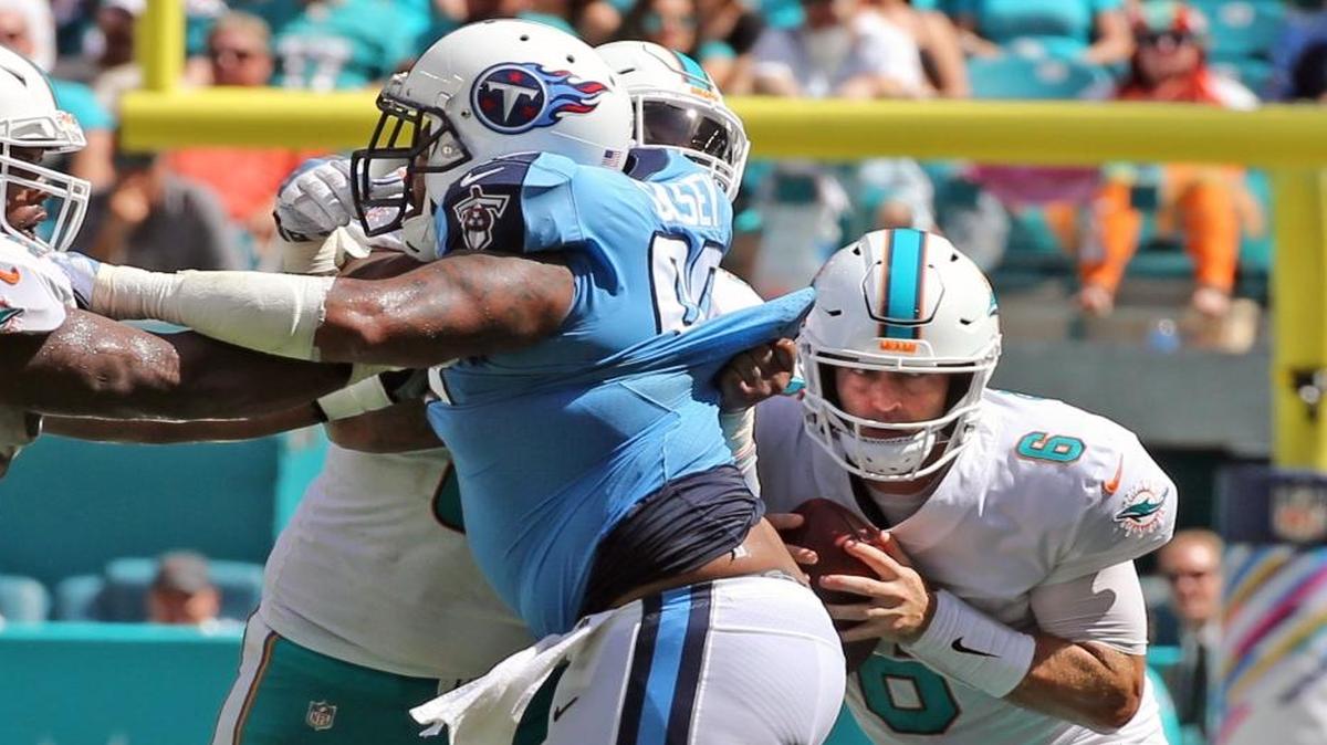 Miami Dolphins quarterback Jay Cutler ducks down behind linemen as he looks for a receiver as they play the Tennessee Titans in the second quarter at Hard Rock Stadium in Miami Gardens, Florida, October 8, 2017.
