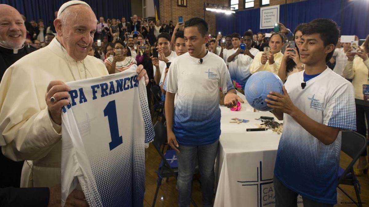 
Pope Francis holds a jersey with his name and number 1 printed on it, during a visit to Our Lady Queen of Angels School in East Harlem, New York on Friday Sept. 25, 2015.

