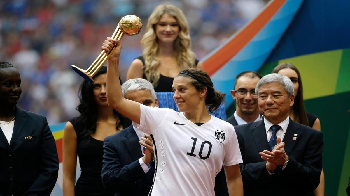 
United States' Carli Lloyd holds the Golden Ball trophy for being the tournament MVP as she stands with tournaments officials after the team beat Japan in the FIFA Women's World Cup soccer championship in Vancouver, British Columbia, Canada, Sunday, July 5, 2015. 
