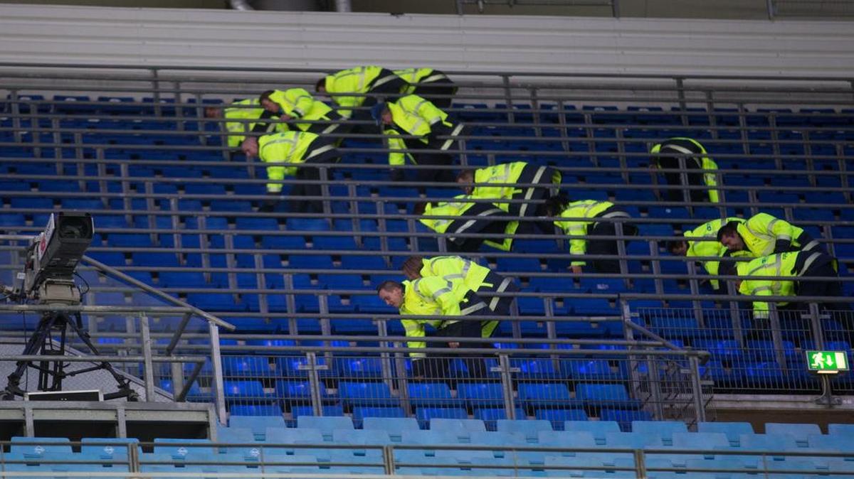 German police officers search between the seats of the stadium before a Bundesliga soccer match between Hamburger SV and Borussia Dortmund in Hamburg, Germany, on Friday. Security is heightened after the Paris attacks.