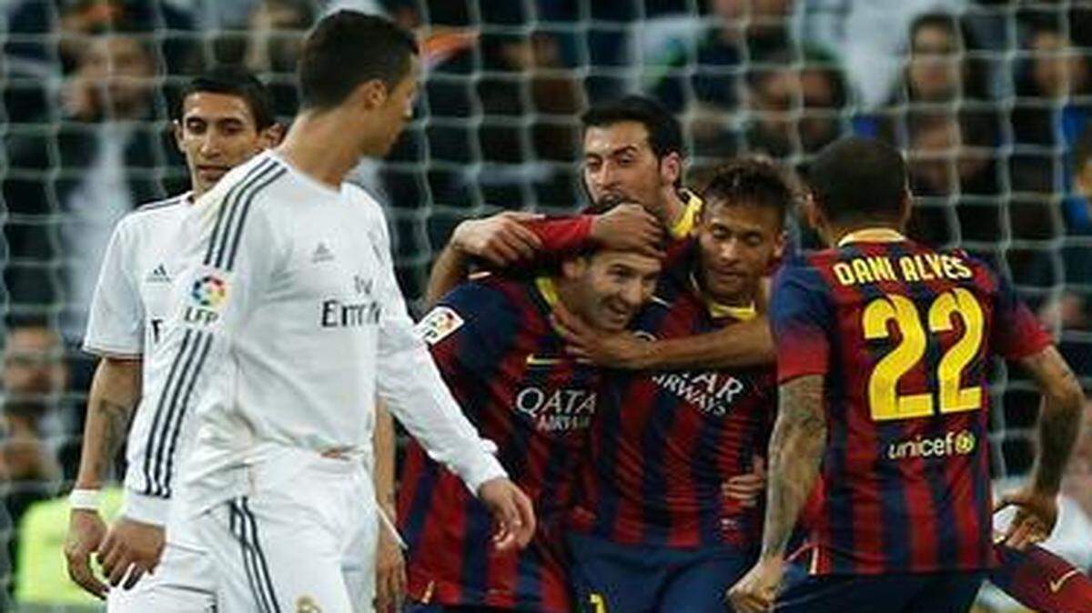 
Lionel Messi of Barcelona celebrates his goal with Neymar as Cristiano Ronaldo of Real Madrid looks back in March 2014. 
