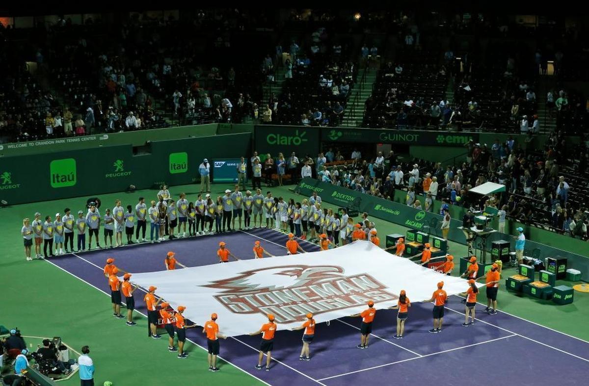 Members of the Marjory Stoneman Douglas High School tennis team stand with players during a ceremony honoring the victims of the school shooting in February, before the start of the night session of the Miami Open tennis tournament, Saturday, March 24, 2018, in Key Biscayne, Fla.