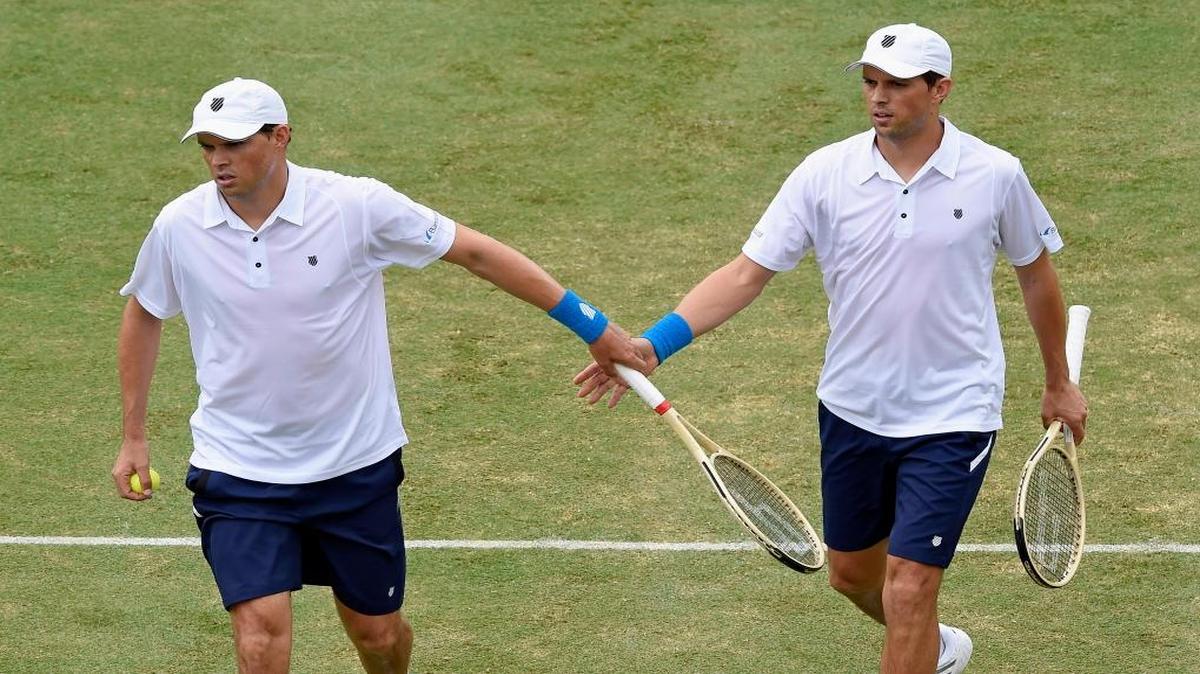 Bob Bryan, left and Mike Bryan of the United States shake hands between points while playing against Australia's Lleyton Hewitt and John Peers during their Davis Cup doubles match in Melbourne, Australia, Saturday, March 5, 2016.